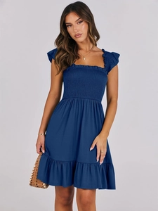 Detail of smocked elastic bodice and square neckline with ruffles on a navy blue dress