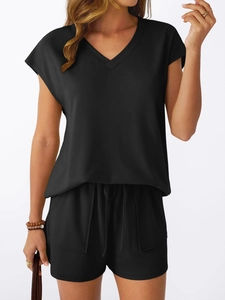 Detail of black V-neck short sleeve top and drawstring shorts with side pockets