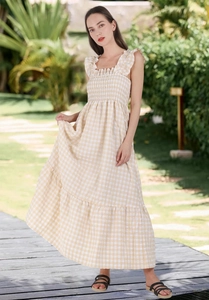 Detail view of yellow plaid dress featuring smocked chest and ruffled shoulder straps