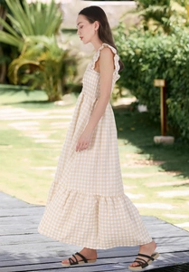 Detail view of yellow gingham maxi dress featuring smocked bodice and ruffled straps