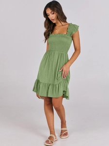 Close-up of smocked bodice detail and square neckline on grass green summer dress