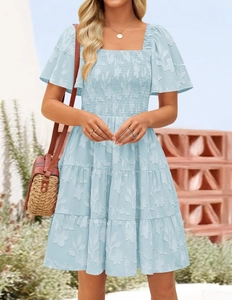 Detail of square neck smocked dress featuring floral jacquard and tiered blue skirt