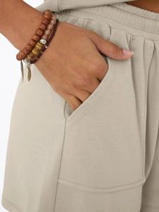 Detail of elastic waistband and side pockets on beige cotton casual shorts for women
