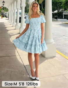 Detail of square neck smocked dress with leaf pattern and tiered ruffle layers