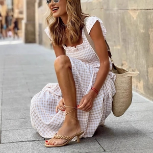 Lace-up kitten heel sandals with woven thong straps in light camel worn on European street