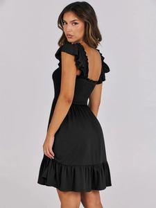 Detailed view of the smocked bodice and ruffled shoulder straps on this black summer dress
