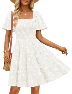 Detail of smocked waist and floral jacquard fabric on a white square neck dress