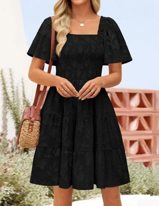Detail of square neckline and smocked bodice with floral embroidery on black dress