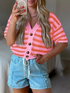 Close-up of pink and orange wavy striped knit cardigan with V-neck and brown buttons