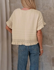 Detailansicht der Rüschenärmel und des Lochstrickmusters bei diesem beigen Sommerpullover