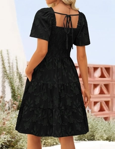 Back view of black floral texture dress with elastic waist and delicate neck ties