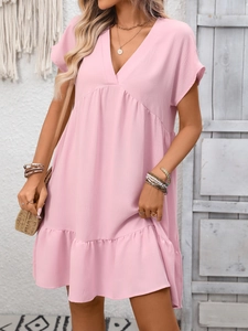 Detail des rosa V-Ausschnitt Sommerkleids mit Rüschensaum und Strand-Accessoires