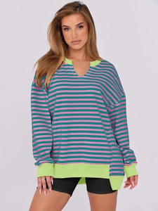 Detail of V-notch neckline with neon green ribbed trim on colorful striped sweatshirt