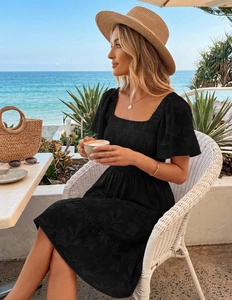 Close-up of black square-neck floral dress with smocked chest and ruffle sleeves