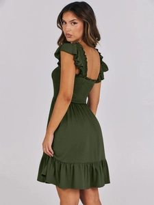 Detailed view of the smocked bodice and ruffled shoulder straps on the green dress