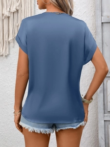Rear view of a blue short sleeve satin top with rolled cuffs on a fashion model