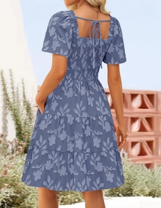 Detail of blue floral jacquard dress featuring tiered skirt and tie-back square neckline