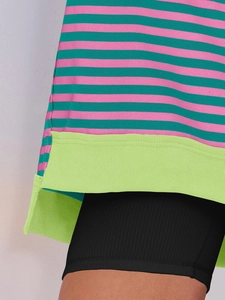 Detail of pink and teal striped knit sweater showing the bright green ribbed hemline