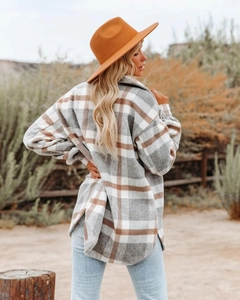 Detail of checkered flannel shacket featuring a curved hem and side slit in autumn style