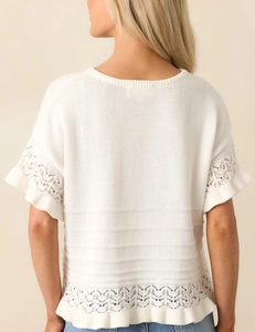 Detail des weißen Strickpullovers mit Spitze, Rüschen und horizontalem Strickmuster