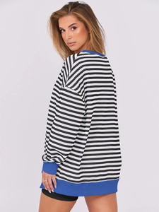 Detail of blue ribbed cuffs and hem on oversized black and white striped sweatshirt