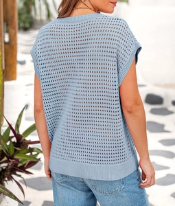 Detailed back view of light blue hollow-out knit sweater with ribbed edges in sunlight