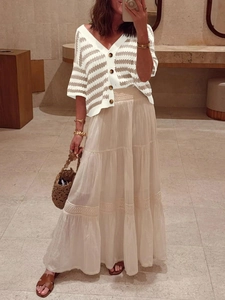 Detail of V-neck striped knit cardigan paired with a tiered lace crochet midi skirt
