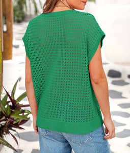 Detail of green hollow-out knit texture and ribbed hem on a summer casual top