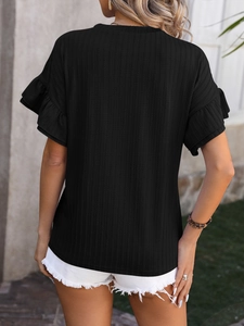 Détail d'un t-shirt noir côtelé avec des manches à volants féminines et coupe ajustée