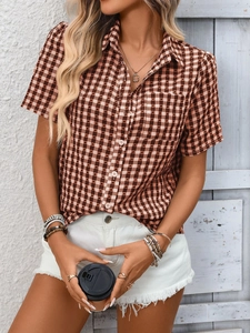 Détail d'une chemise à manches courtes à carreaux marron avec col classique et poche poitrine