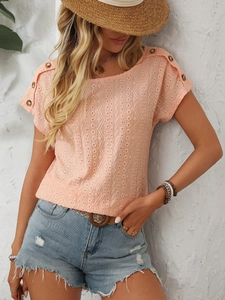 Detail of coral lace t-shirt showing shoulder buttons and geometric hollow texture
