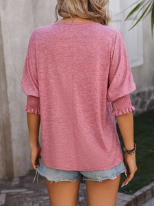 Detail of smocked ruffle sleeves on a pink V-neck casual top with textured cotton fabric