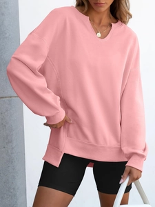 Detail view of pink pullover hoodie with V-neck notch, dropped shoulders and side slits