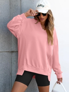Detail of pink oversized sweatshirt with notched neckline and high-low side slit hem