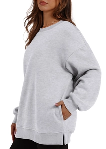 Detail of oversized grey sweatshirt showing ribbed cuffs and functional side slit pockets