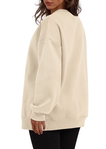 Detail of beige oversized sweatshirt showing dropped shoulder and ribbed cuffs fabric