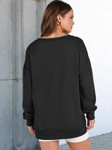 Back view of women's oversized black sweatshirt with dropped shoulders and ribbed cuffs