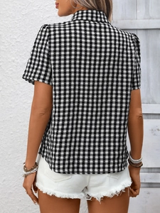 Détail d'une chemise à manches courtes à carreaux noirs et blancs et manches bouffantes