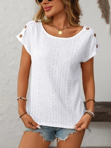 Detail of white eyelet lace top featuring textured wavy embroidery and wooden shoulder buttons
