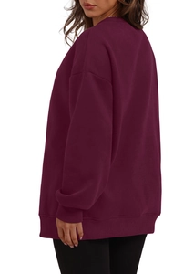 Detail of burgundy oversized crewneck sweatshirt with ribbed cuffs and drop shoulder seam