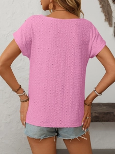 Detail of pink eyelet embroidery texture and wavy patterns on a summer casual top