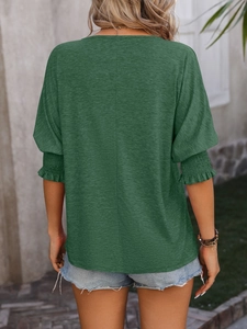Detail view of smocked elastic cuffs and ruffled sleeves on dark green cotton T-shirt