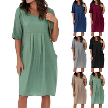 Detail of short sleeve pleated cotton linen dress featuring crew neck and side pockets