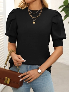 Close-up of black short sleeve knit top featuring elegant puff sleeves and a round neckline