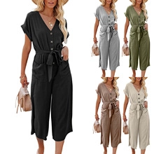 Detail of V-neck short sleeve summer jumpsuit with button down front and waist tie