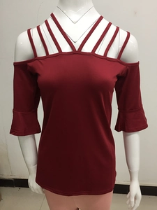 Detail of burgundy off-shoulder top featuring stylish crisscross neck straps and bell sleeves