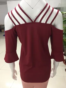 Detail of burgundy off-shoulder top with crisscross straps and flared bell sleeves