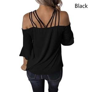 Detail of black off-the-shoulder top featuring multiple thin straps and ruffled bell sleeves