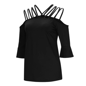 Close-up of black cold-shoulder top featuring crisscross straps and bell sleeves detail