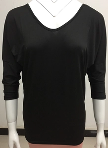 Detail of loose-fit black V-neck top featuring wide batwing sleeves and premium texture